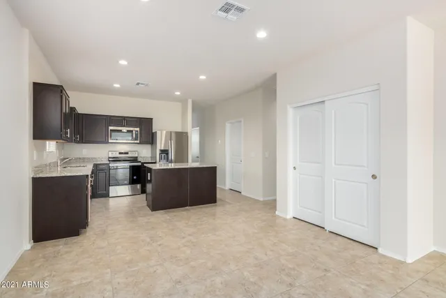 a large kitchen with stainless steel appliances kitchen island granite countertop a sink and cabinets