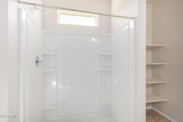 an empty room with a window and a fan