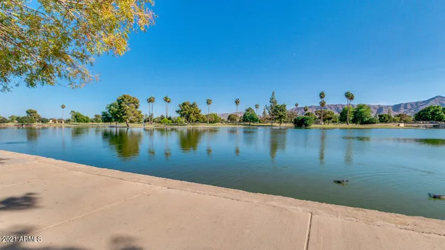 a view of a lake with a floor to ceiling window and potted plants