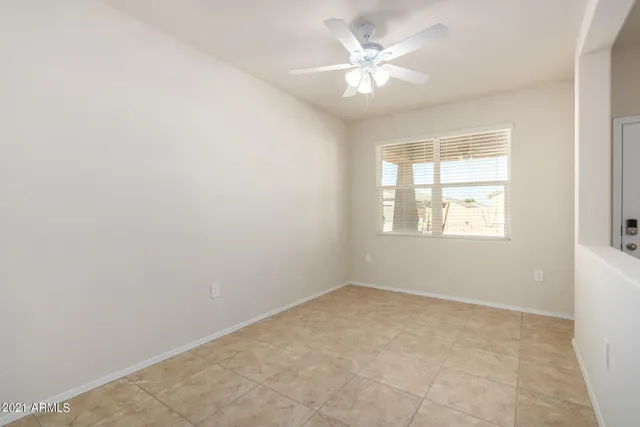 an empty room with a chandelier fan and closet area