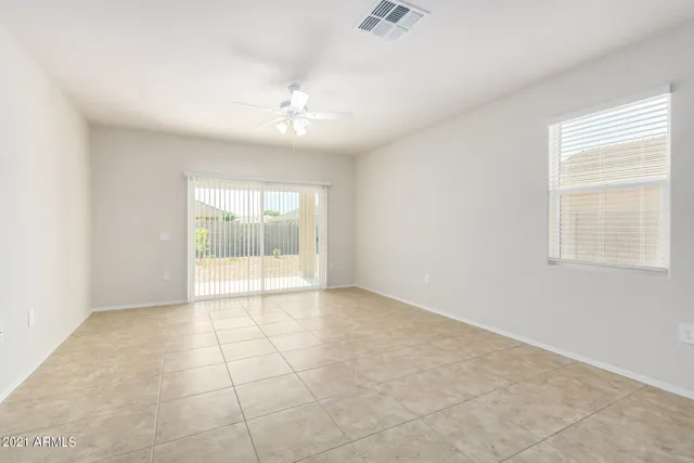 an empty room with a ceiling fan and glass door