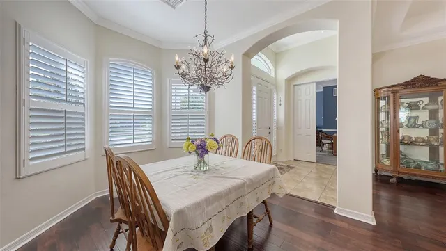 a living room with furniture a large window and wooden floor