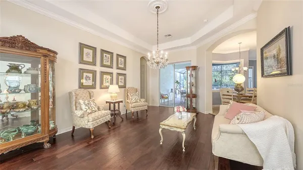 a living room with furniture a dining table and a chandelier