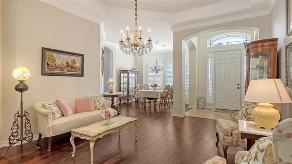 a living room with furniture a chandelier and a fireplace
