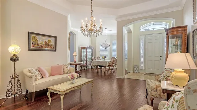 a living room with furniture a chandelier and a fireplace