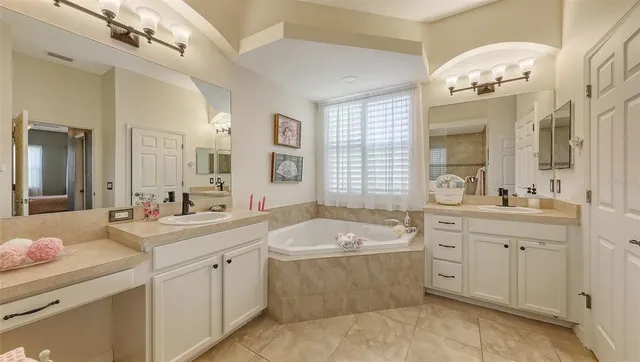 a bathroom with a sink vanity tub and a mirror