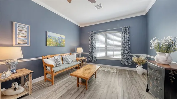 a living room with furniture and a night stand with wooden floor