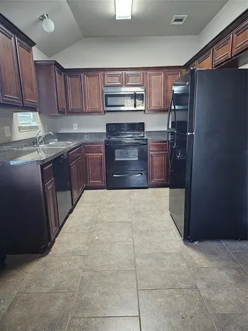 a kitchen with granite countertop a refrigerator and a stove