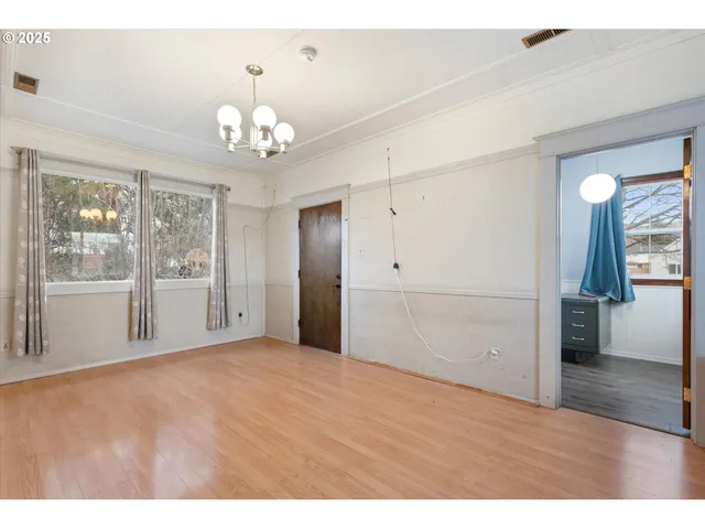 a view of empty room with wooden floor and fireplace