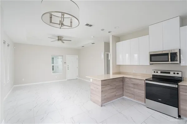 a kitchen with granite countertop white cabinets and stainless steel appliances