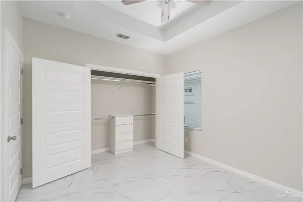 an empty room with closet and windows