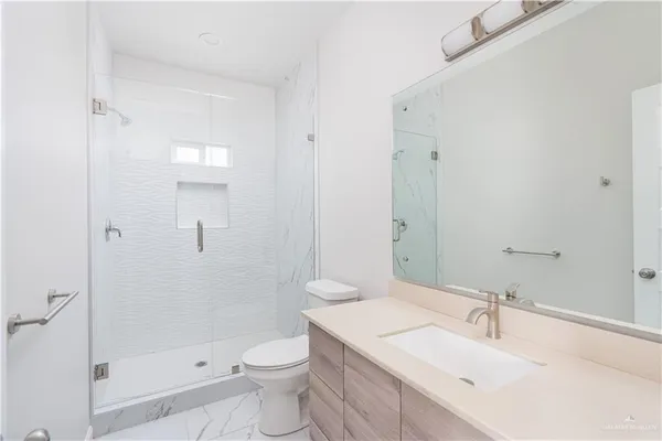 a bathroom with a sink toilet vanity and shower