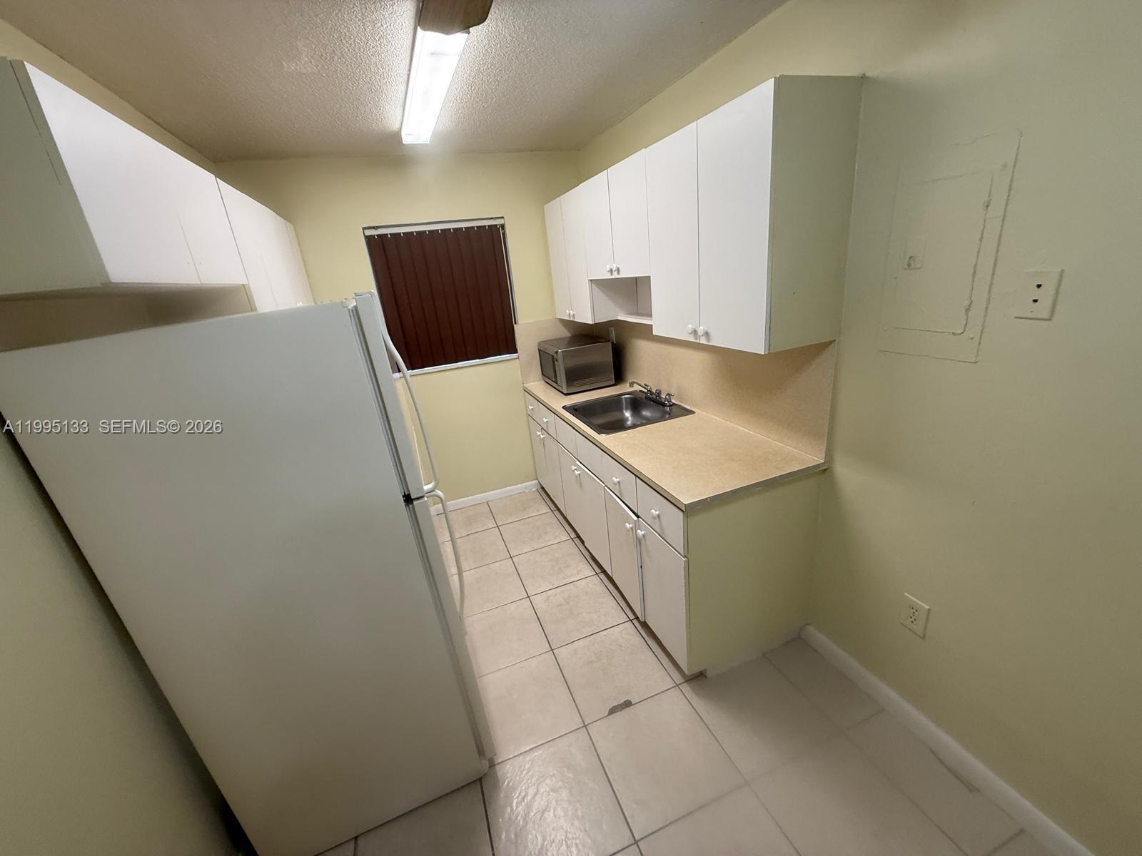 17530 Northwest 68th Avenue, Unit C4013 Hialeah, FL 33015 - Photo 2 of 4 a kitchen with a stove and a refrigerator