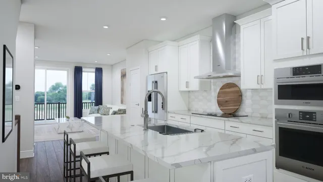 a kitchen with stainless steel appliances granite countertop a stove top oven a sink dishwasher a dining table and chairs with wooden floor