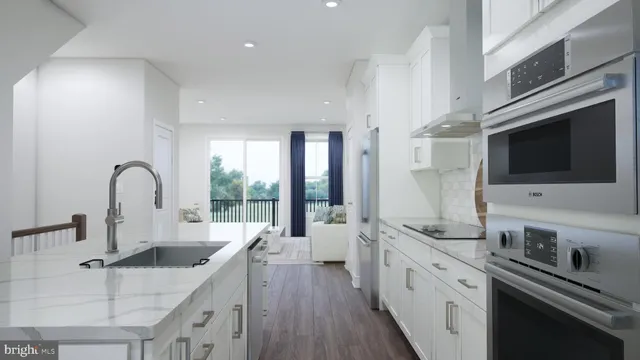 a large kitchen with stainless steel appliances granite countertop a lot of counter space and wooden floors