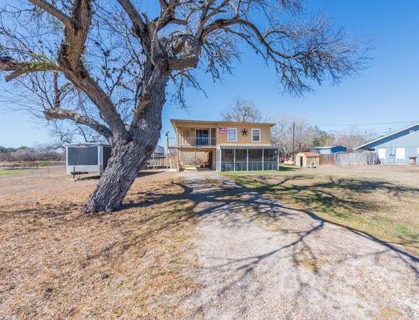 a view of a house with a tree in a yard