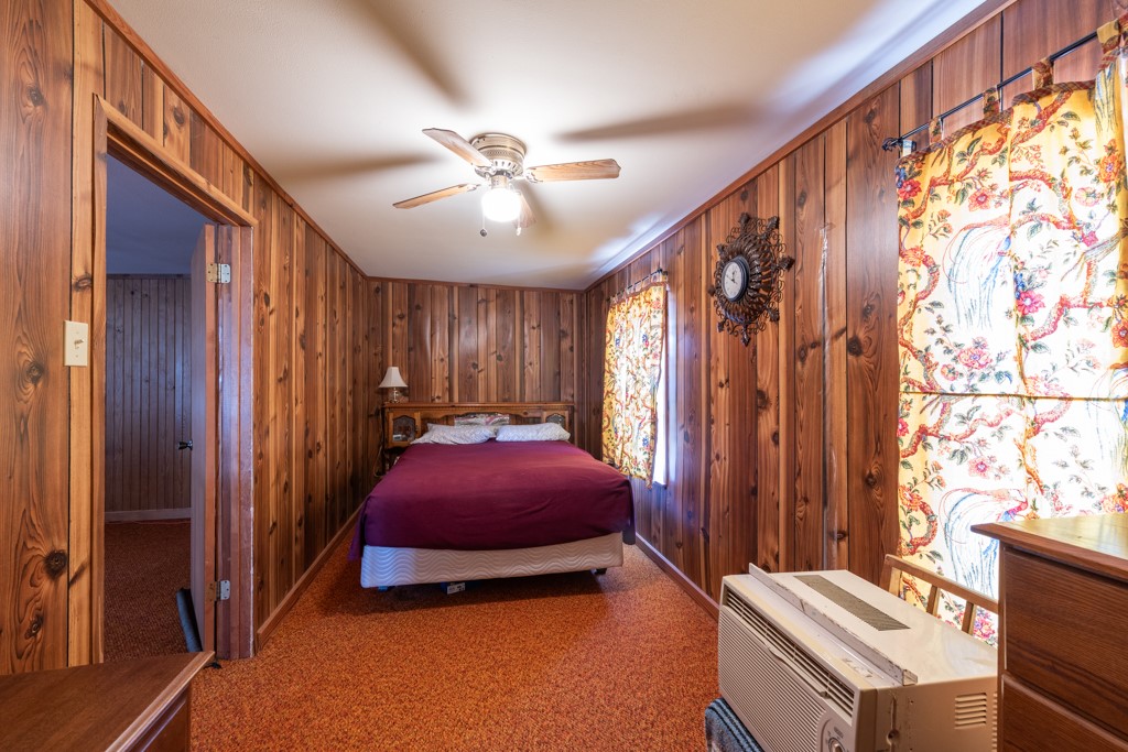 167 Buckeye Knoll Road George West, TX 78022 - Photo 16 of 40 a bedroom with a bed and a chandelier