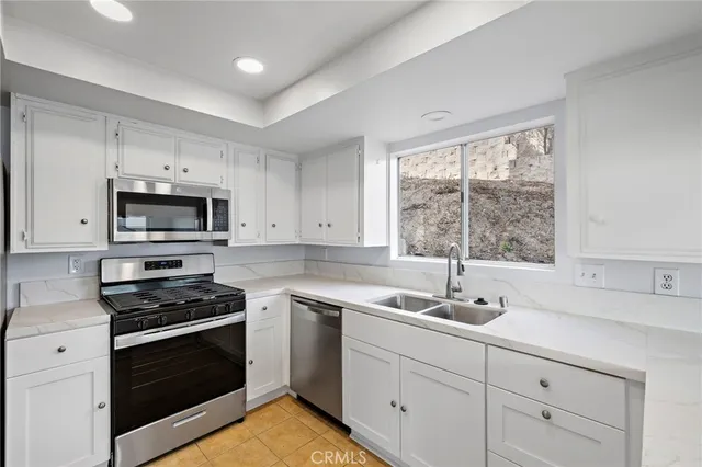 a kitchen with stainless steel appliances white cabinets a stove and a microwave