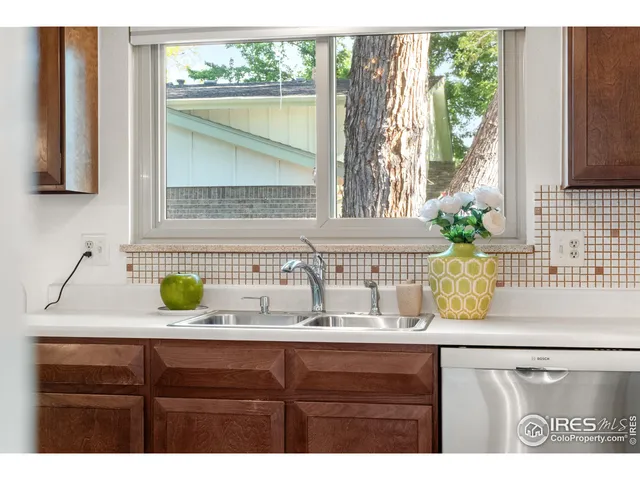 a bathroom with a granite countertop sink and a window