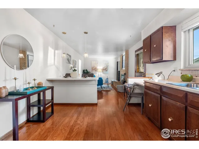 a kitchen with stainless steel appliances granite countertop a stove a sink dishwasher and a dining table with wooden floor