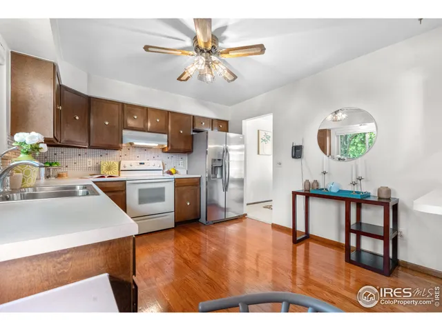 a living room with stainless steel appliances kitchen island granite countertop furniture and a wooden floor