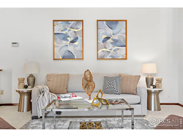 a living room with furniture a rug and a lamp