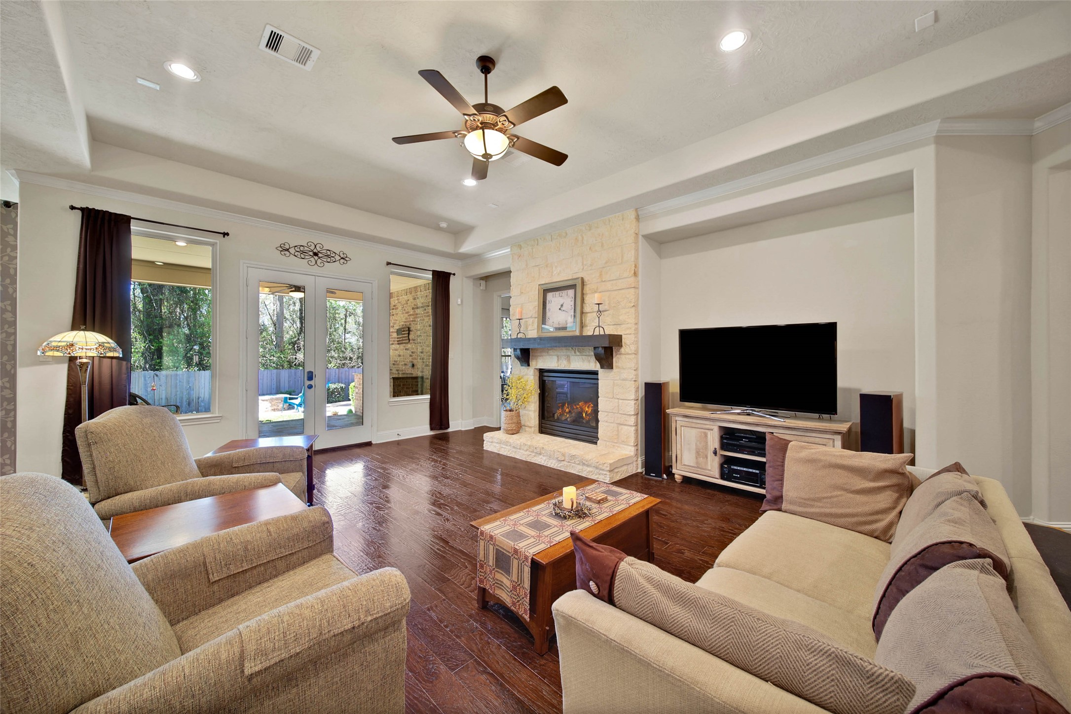 3234 Explorer Way Conroe, TX 77301 - Photo 24 of 46 Stone fireplace, custom ceiling details, and generous seating areas create an ideal gathering space.