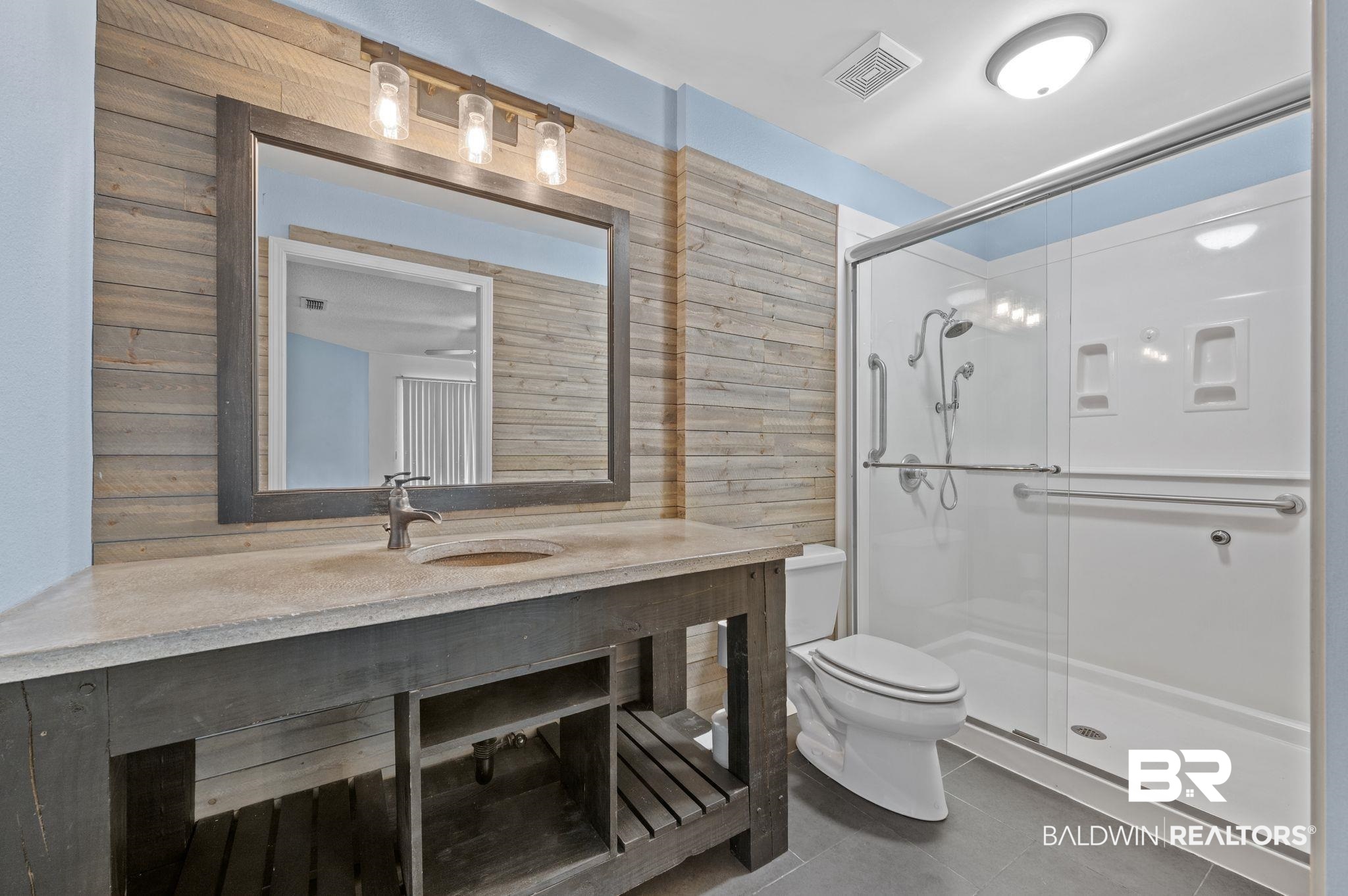 3716 Pepper Ridge Drive Mobile, AL 36693 - Photo 12 of 20 Bathroom featuring toilet, tile patterned flooring, a shower with door, and wooden walls