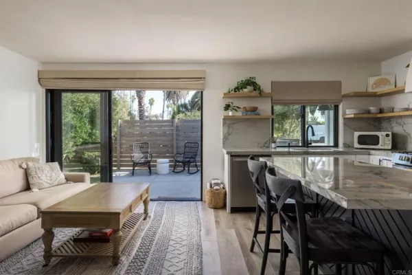 a kitchen with stainless steel appliances granite countertop a table chairs stove and white cabinets