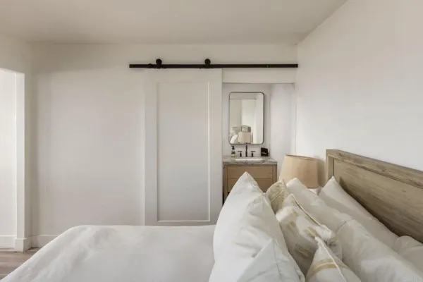 a view of a bedroom with bed and mirror
