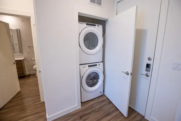 a storage room with wooden floor washer and dryer