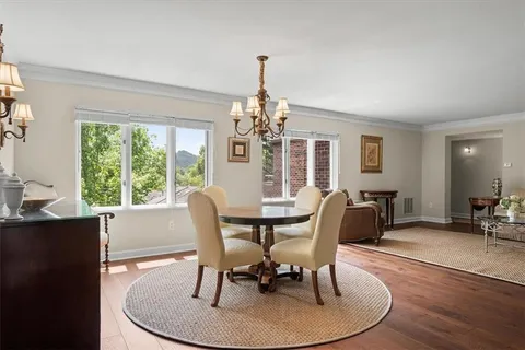 a dining room with furniture a large window and wooden floor