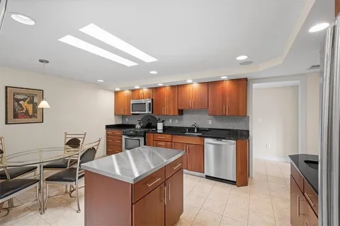 a kitchen with a stove a refrigerator and chairs