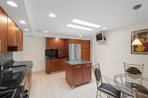 a kitchen with stainless steel appliances a stove a sink a microwave a refrigerator and cabinets
