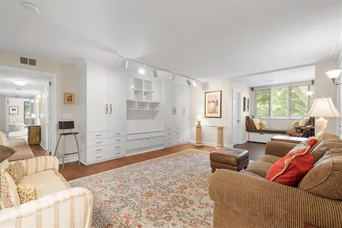 a living room with furniture two windows and a chandelier