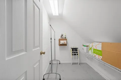 a view of a hallway with wooden floor and a bathroom