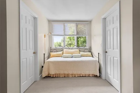 a bedroom with a bed and a large window