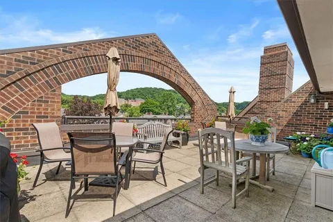 a view of a patio with table and chairs potted plants and floor to ceiling window