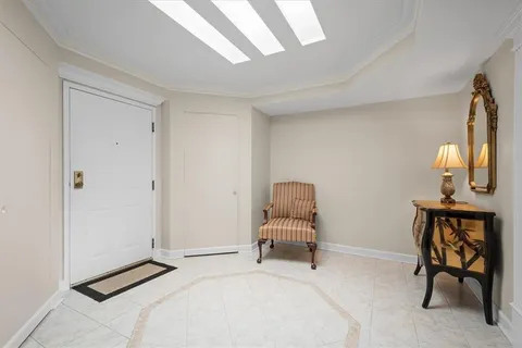a room with a chair and potted plant on a table