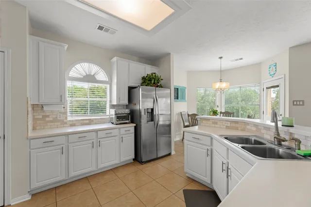 a kitchen with kitchen island white cabinets and refrigerator