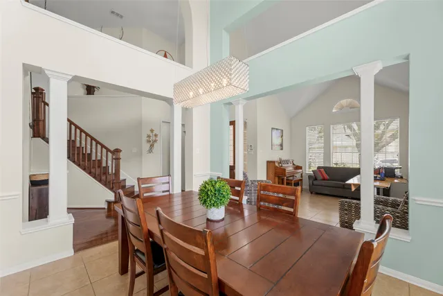 a dining room with furniture potted plants and wooden floor