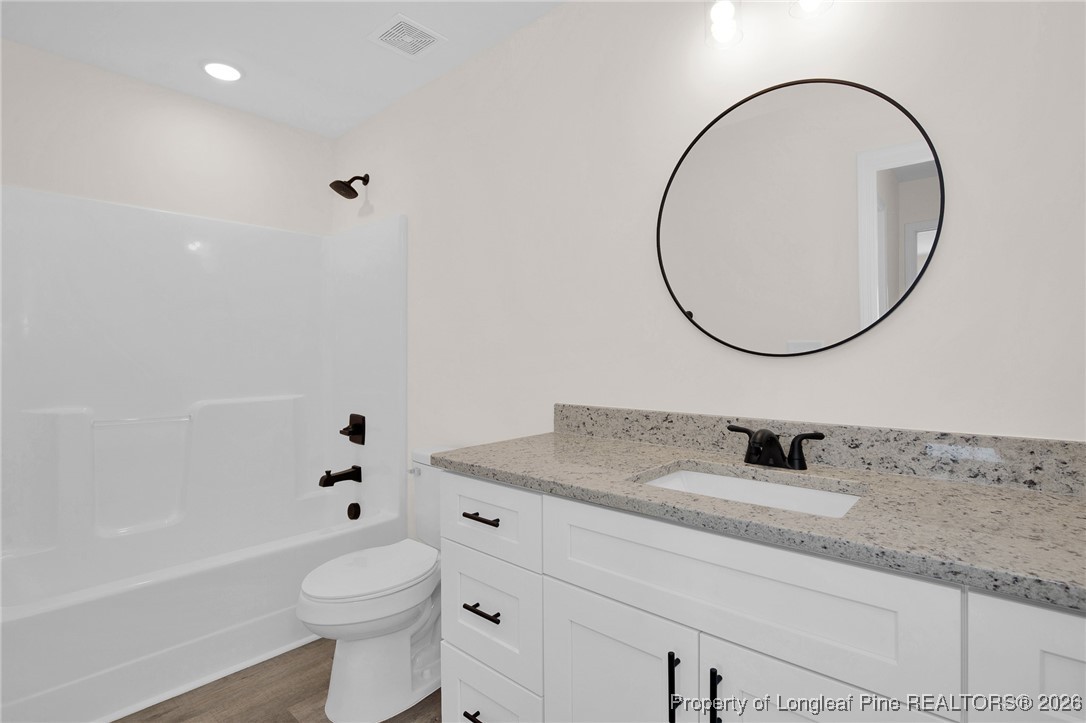 253 Barberry Road Raeford, NC 28376 - Photo 22 of 31 a bathroom with a granite countertop sink mirror vanity and toilet