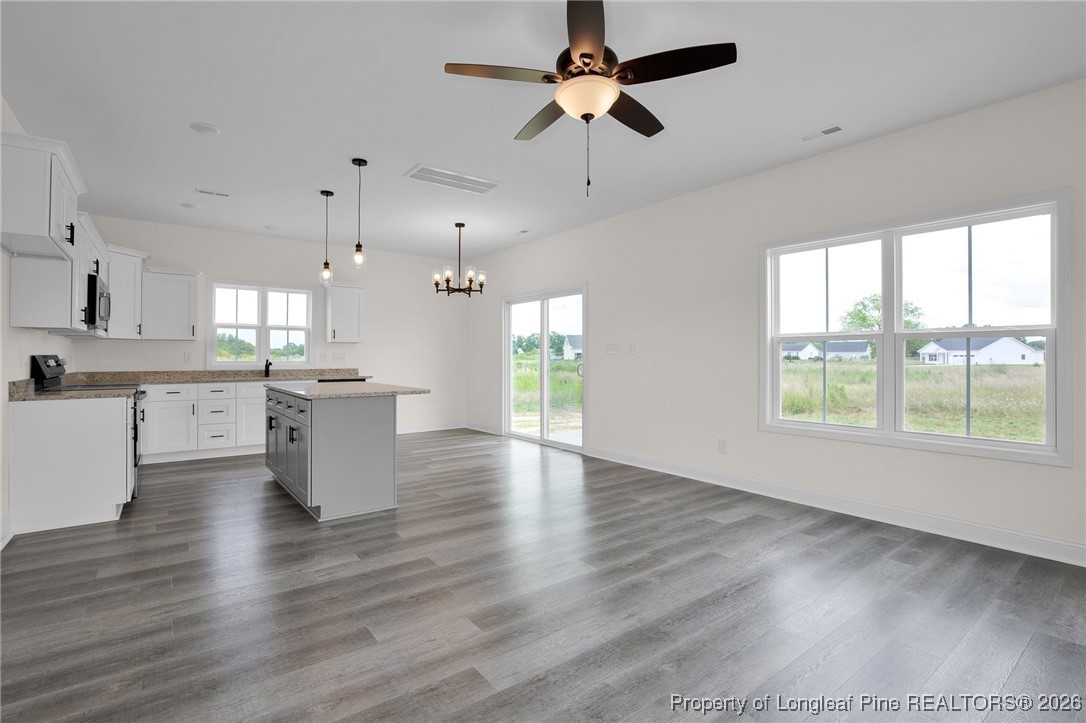 253 Barberry Road Raeford, NC 28376 - Photo 7 of 31 a view of an empty room with wooden floor and a kitchen