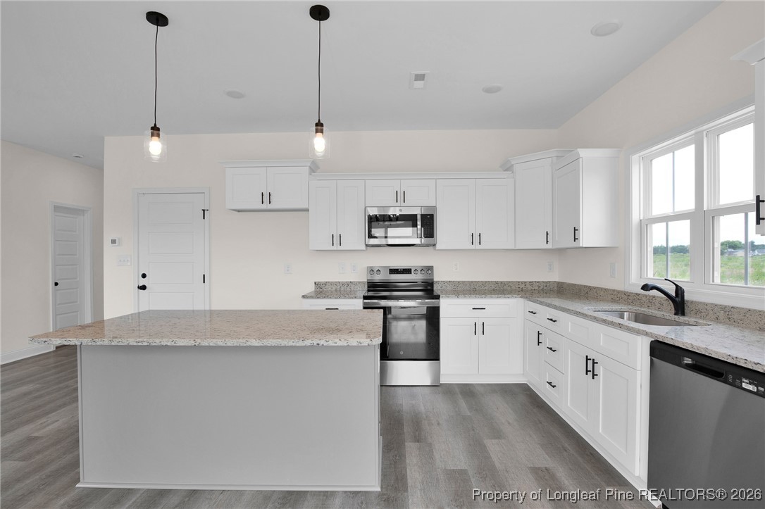 253 Barberry Road Raeford, NC 28376 - Photo 10 of 31 a kitchen with stainless steel appliances granite countertop a sink a stove a refrigerator and white cabinets