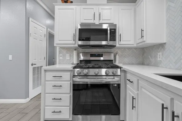 a kitchen with stainless steel appliances a stove and a microwave
