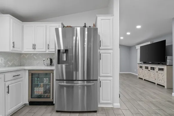 a kitchen with stainless steel appliances a refrigerator stove and white cabinets