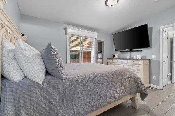 a bedroom with a bed and a flat screen tv