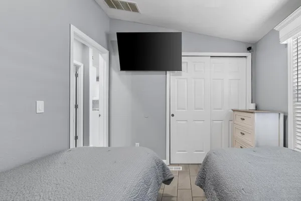 a bedroom with a bed and a flat screen tv