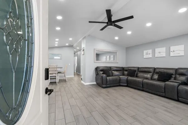 a living room with furniture and a ceiling fan