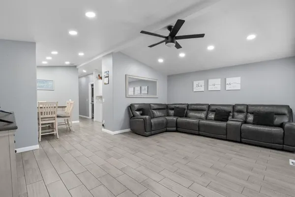 a living room with furniture and a view of kitchen